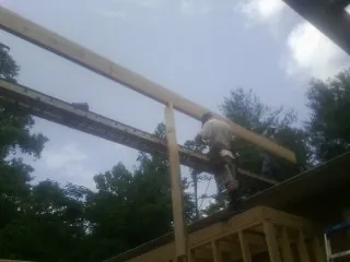 Carpenter setting a ridge beam over a new addition frame — Ice Dam Removal by Roofing Brothers in Rumson