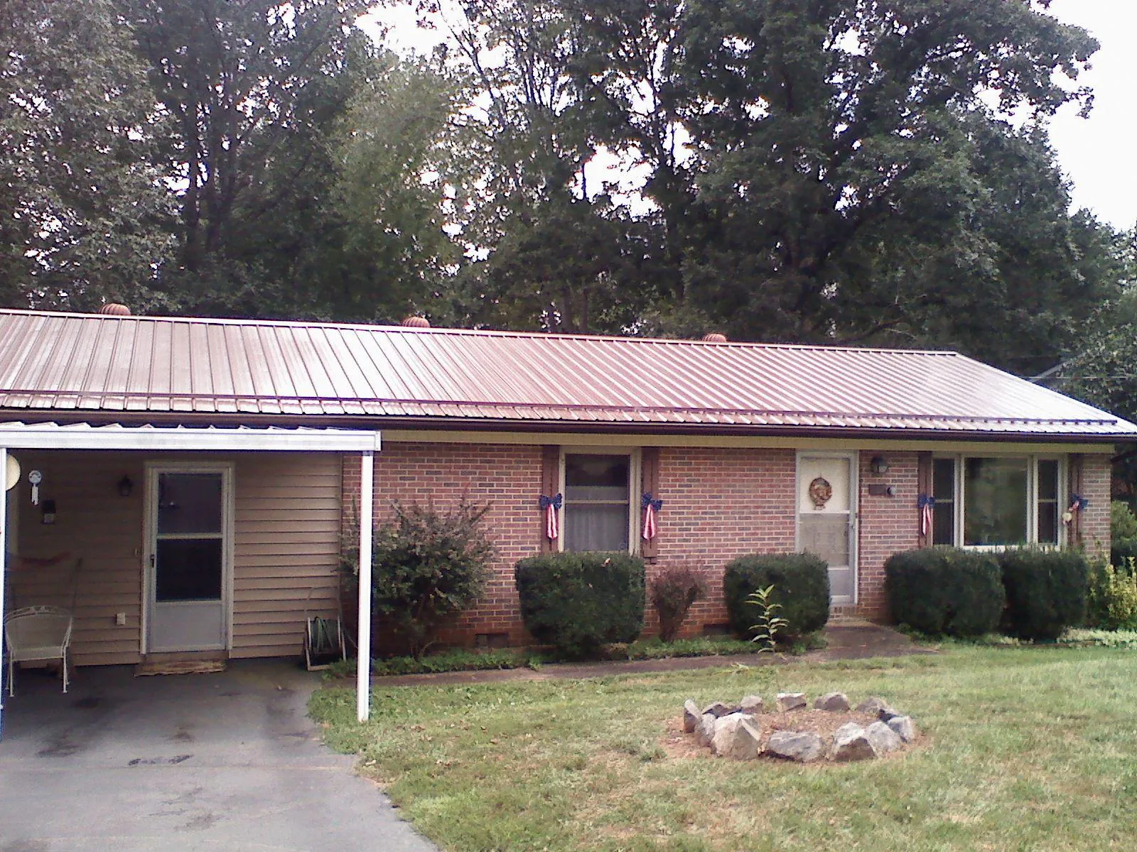 Bronze metal roof and carport on a brick ranch home — Roof Repair work by our crew in Rumson